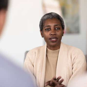 An elderly financial counselor talks to her two clients about their struggles and obstacles
