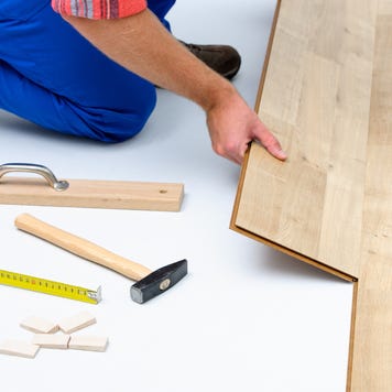 carpenter worker installing laminate flooring in the room