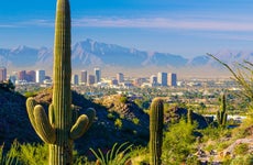 Midtown Phoenix skyline with cacti, mountains, and other desert scenery in the foreground.