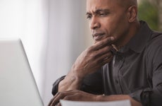 Middle aged Black man on laptop