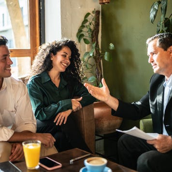 Mid adult couple having a meeting with a financial advisor at a coffee shop