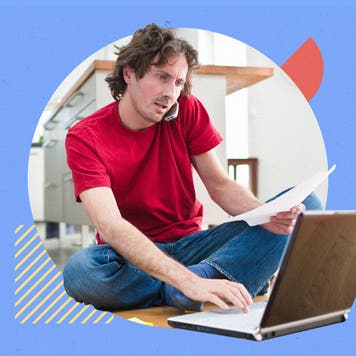 White man works on laptop while talking on a cellphone