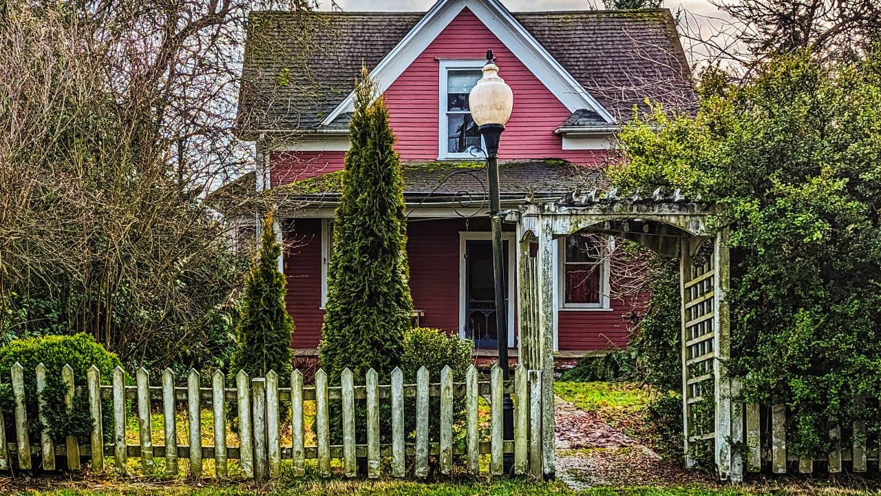 hoto of an old red two-story house in need of maintenance, while still maintaining a quaint appearance