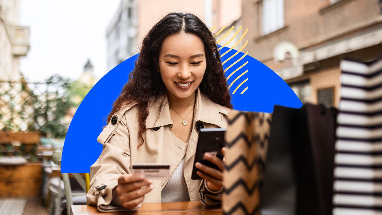 design element of a women smiling while holding a cellphone and credit card in her hands