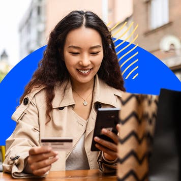 design element of a women smiling while holding a cellphone and credit card in her hands