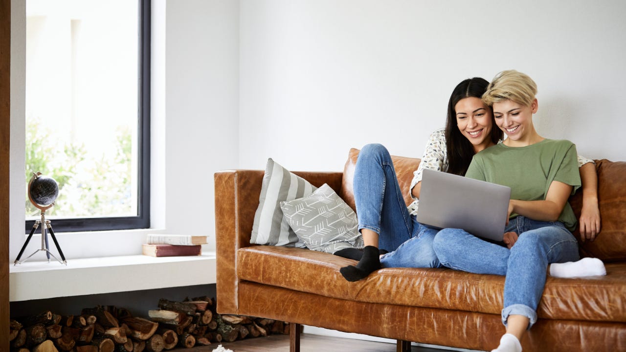 Couple weighing options on a laptop