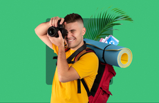 design element displaying a backpacking traveler taking a photo with a palm tree leaf in the background with a solid green background