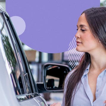 A white woman inspects a car at a dealership.