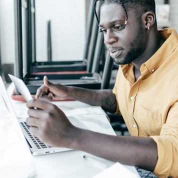Man calculating taxes for a small business on a laptop.