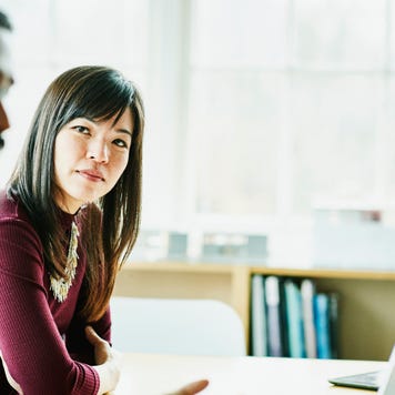 Businesswoman listening to colleague present during client meeting