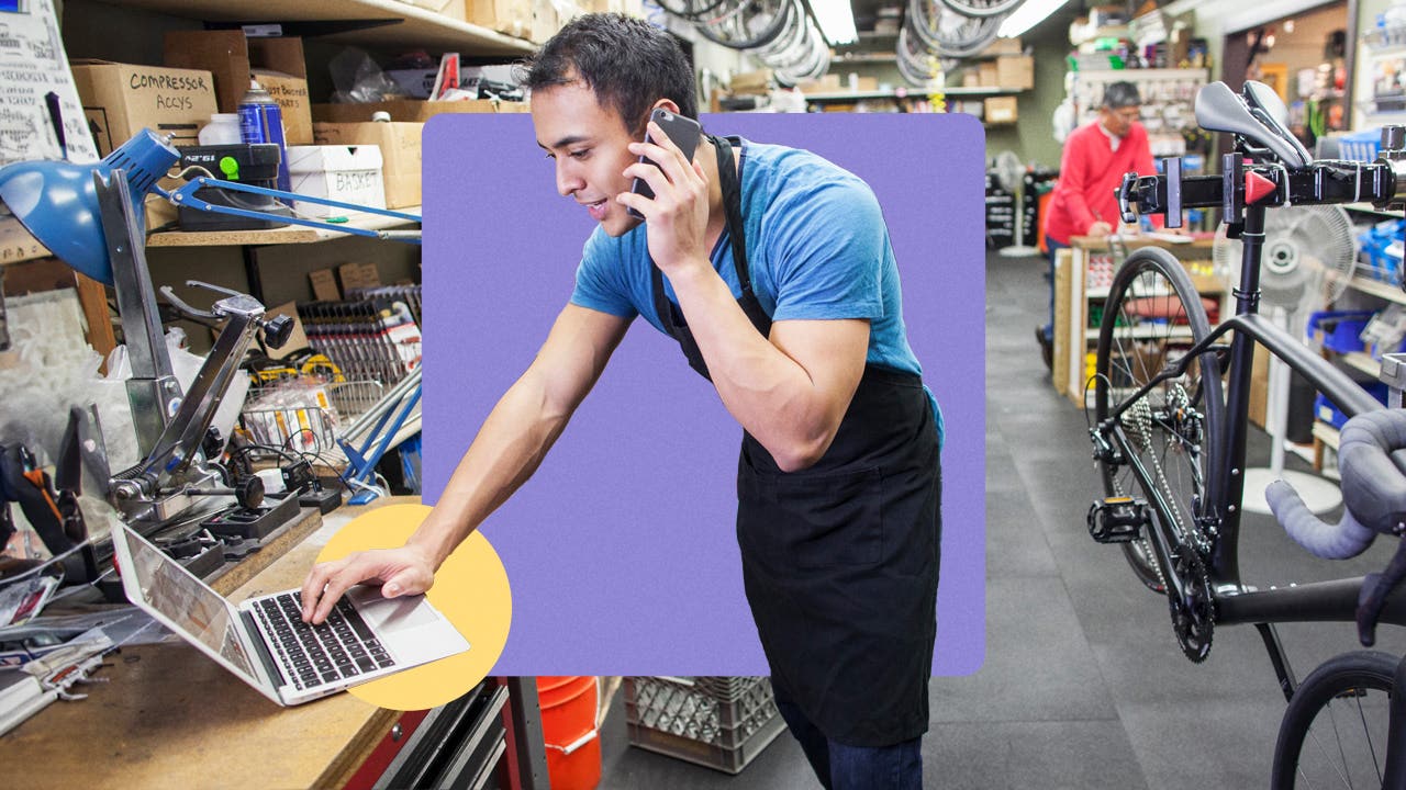 Man reviewing laptop while on the phone.