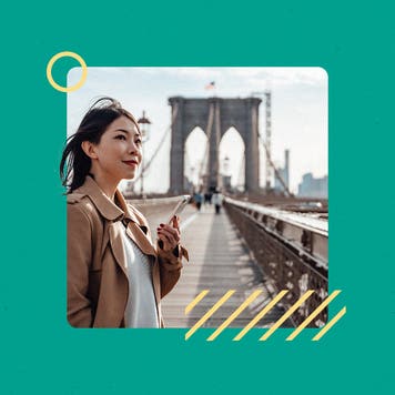 An adult holding a smartphone and standing on a scenic bridge. There is a graphical overlay of solid teal framing this vignette.