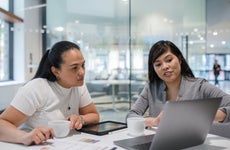 Two coworkers in discussion at a table