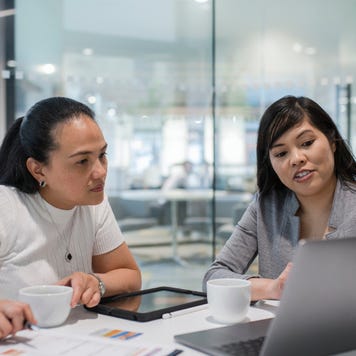 Two coworkers in discussion at a table