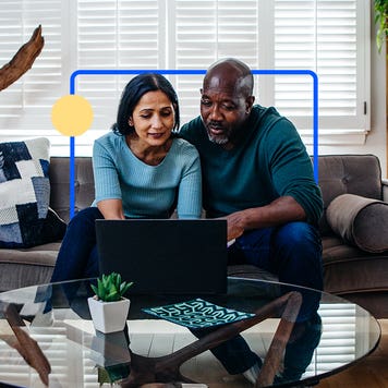 Couple sitting on a couch in front of a laptop