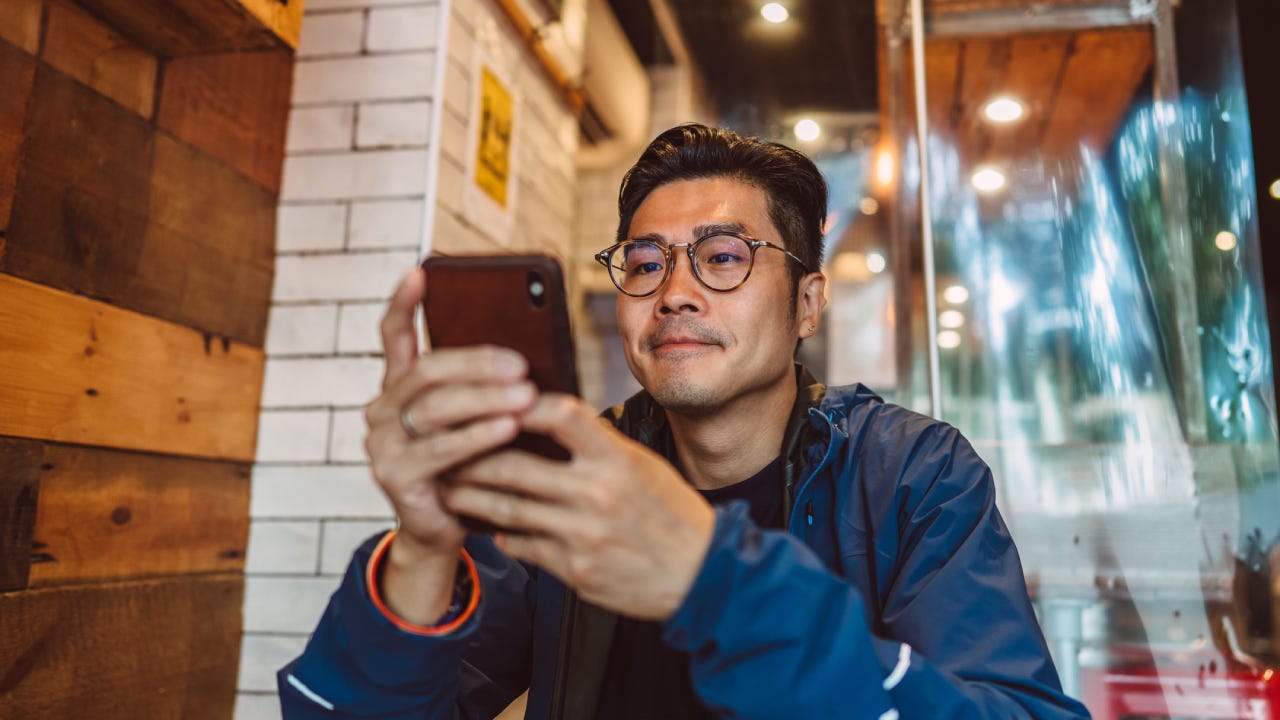 man making order from the digital menu on smartphone in restaurant