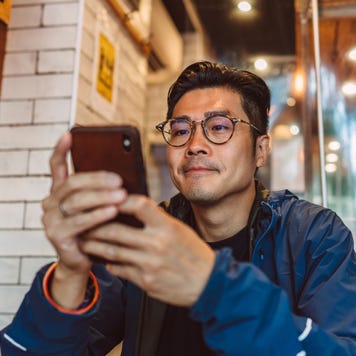 man making order from the digital menu on smartphone in restaurant