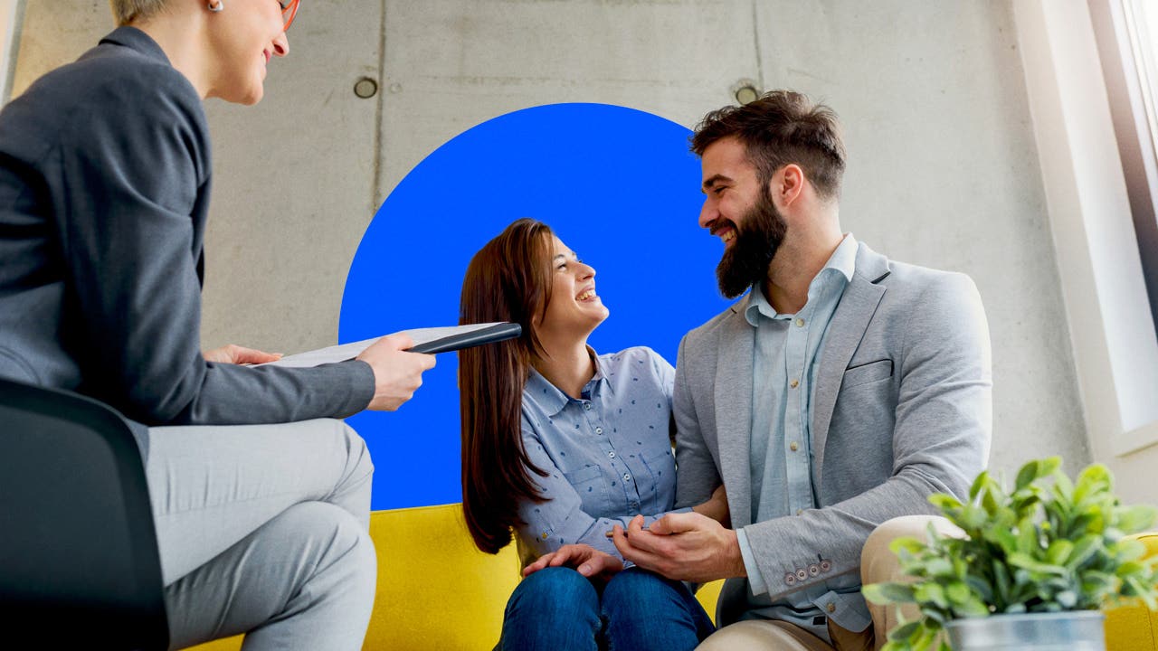 A couple stare lovingly at one another while sitting on a couch.