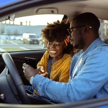 Cheerful using smart phone in car