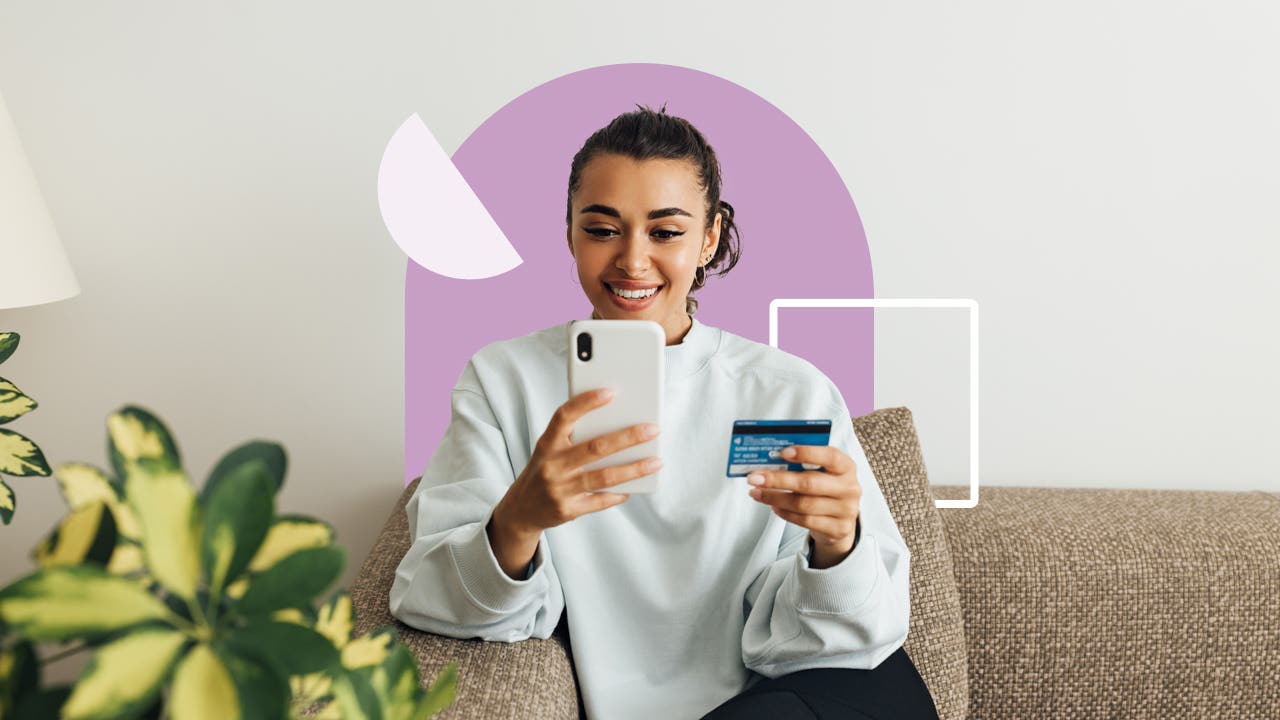 design element of a women sitting on a couch and holding a credit card and phone in each hand