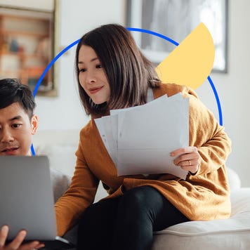 Two people going over documents on a laptop