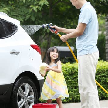 Girl helping father cleaning car