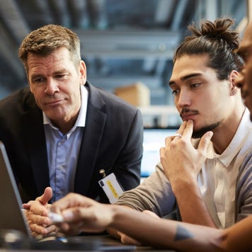Male entrepreneur giving presentation over laptop at desk in creative office