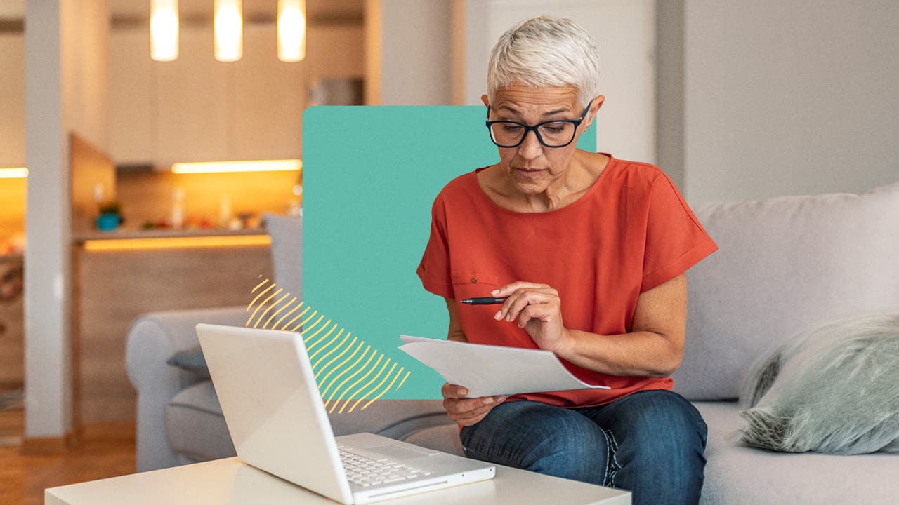 Older woman sitting on a couch, reviewing papers