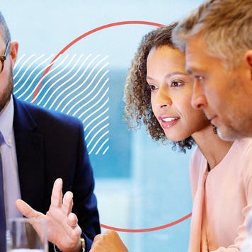 2 men and a woman discuss something at a table.