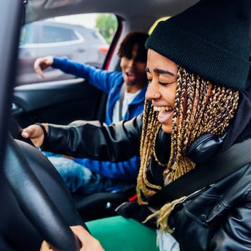 Younger people driving in a car and having fun.