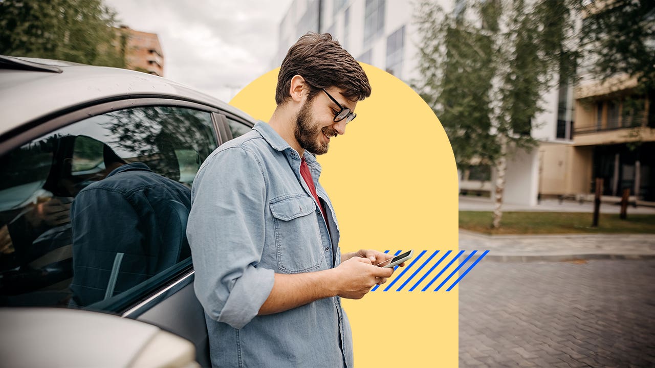 Person leaning against their car and on their smartphone
