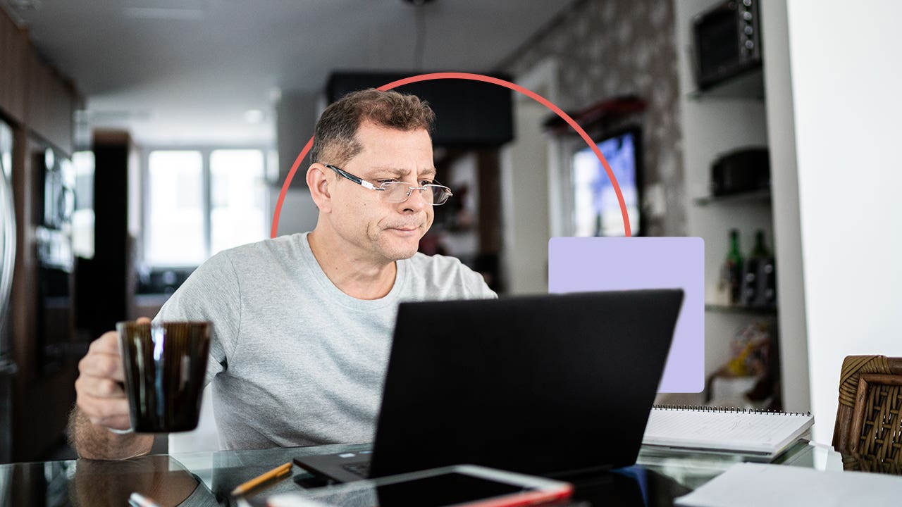 Man with coffee on laptop looking slightly stressed