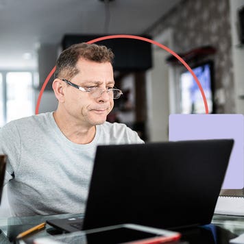 Man with coffee on laptop looking slightly stressed