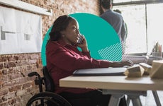A woman in a wheelchair works in her office.