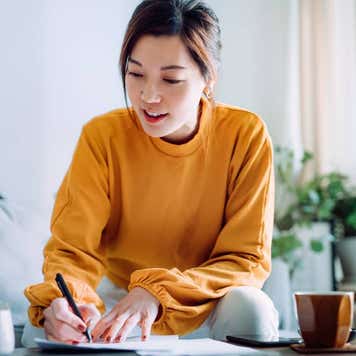 woman holding a pen and signing paperwork