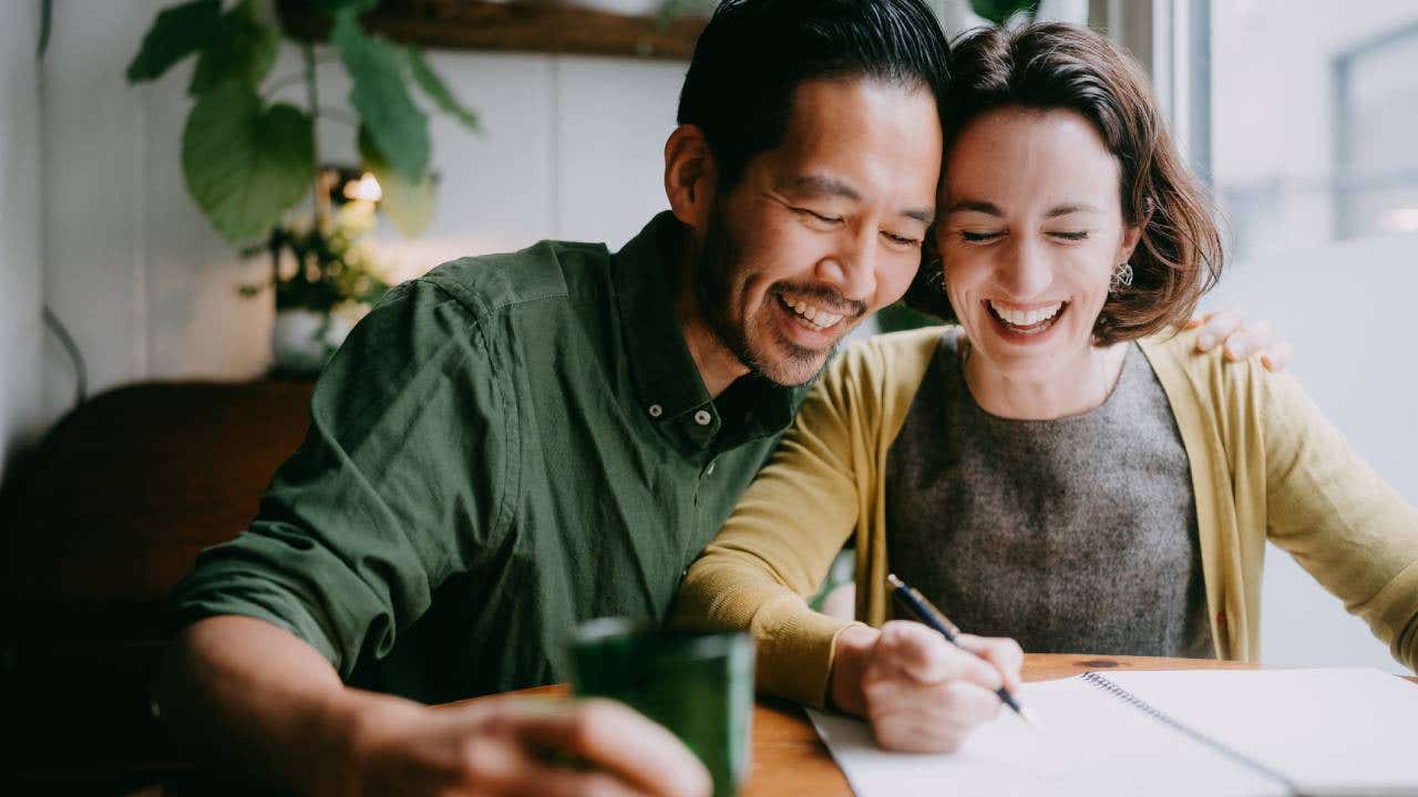 A happy couple doing a prenup agreement