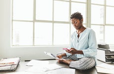 Female entrepreneur using smart phone while sitting on desk in office