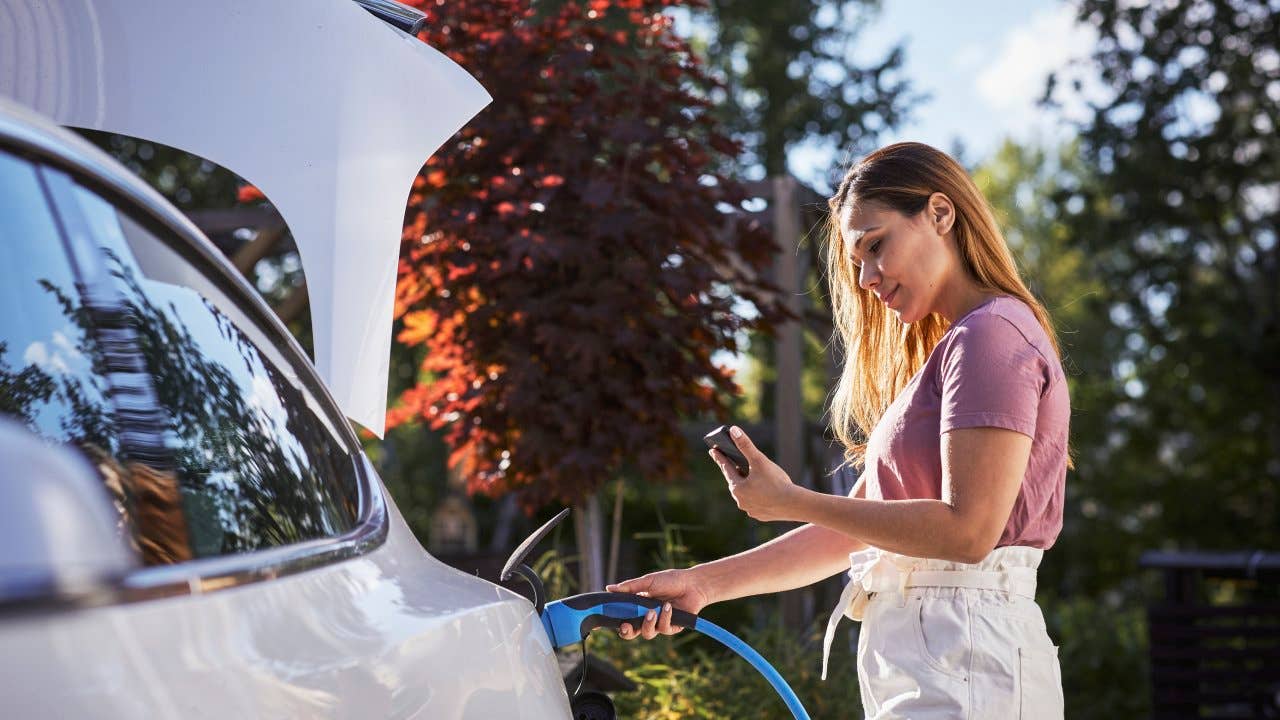 Woman charging electric car