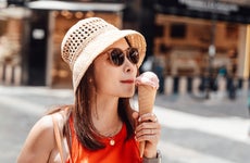 Female tourist eating ice cream cone on the street