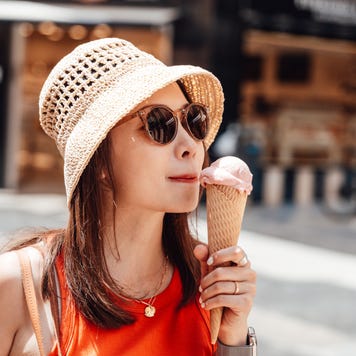 Female tourist eating ice cream cone on the street