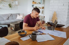 Young man at home, paying bills online