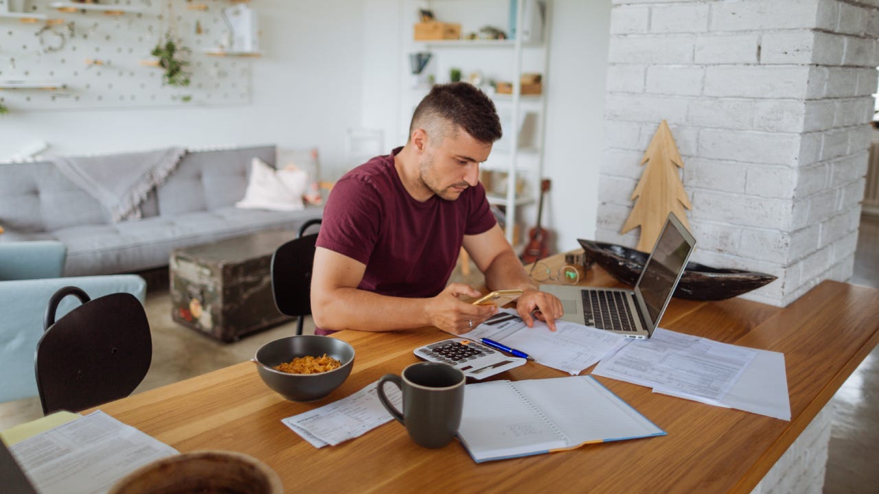 Young man at home, paying bills online