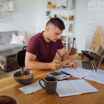 Young man at home, paying bills online