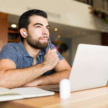freelance worker in the cafe thinking about a new idea while doing remote work using his laptop