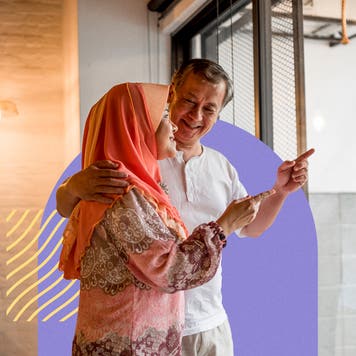 A man and woman look out a window.