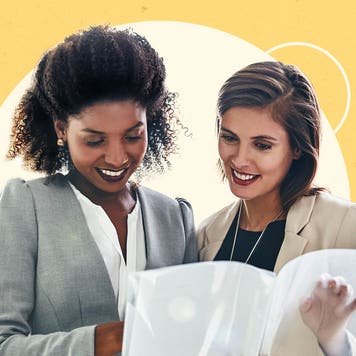 Two women look at documents.
