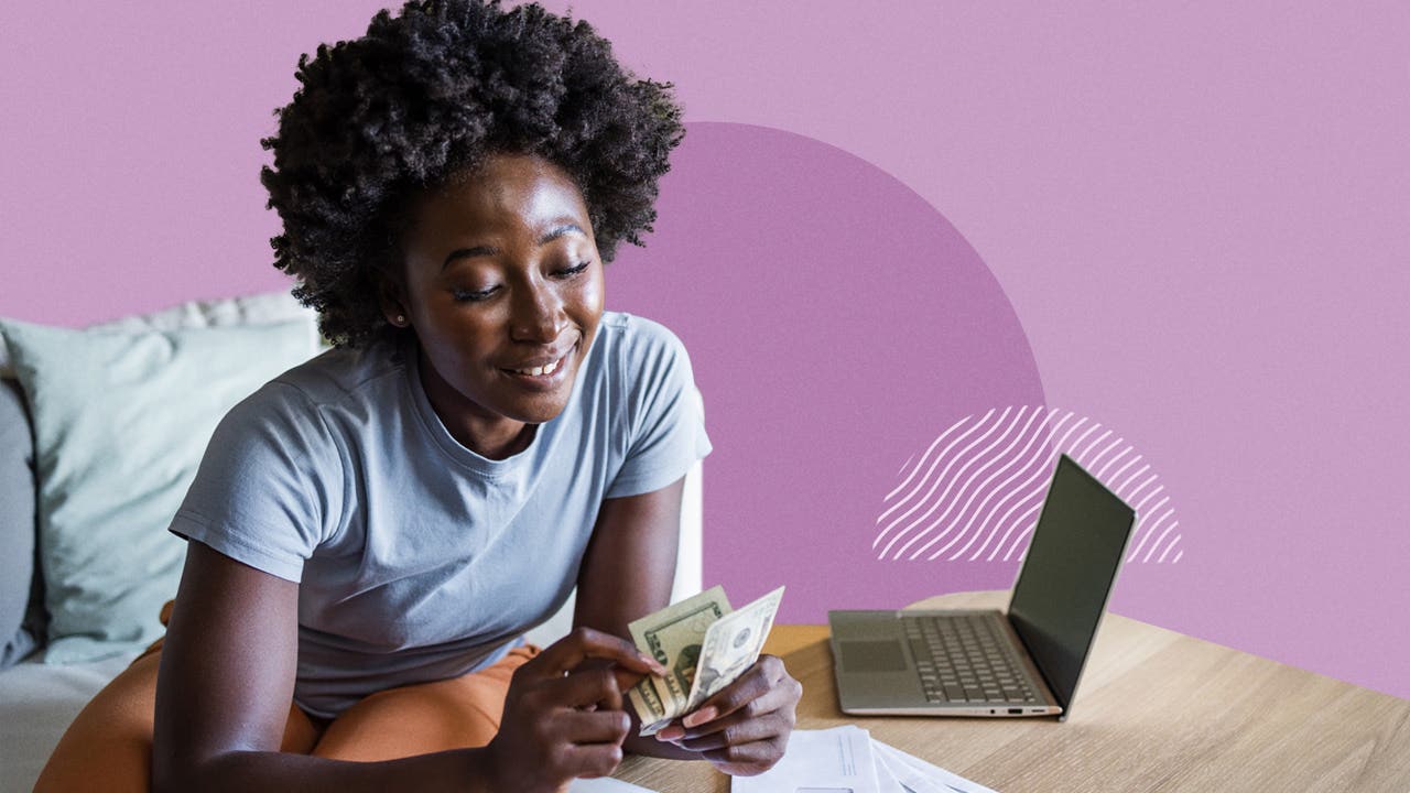 A Gen Z woman counting cash next to a laptop