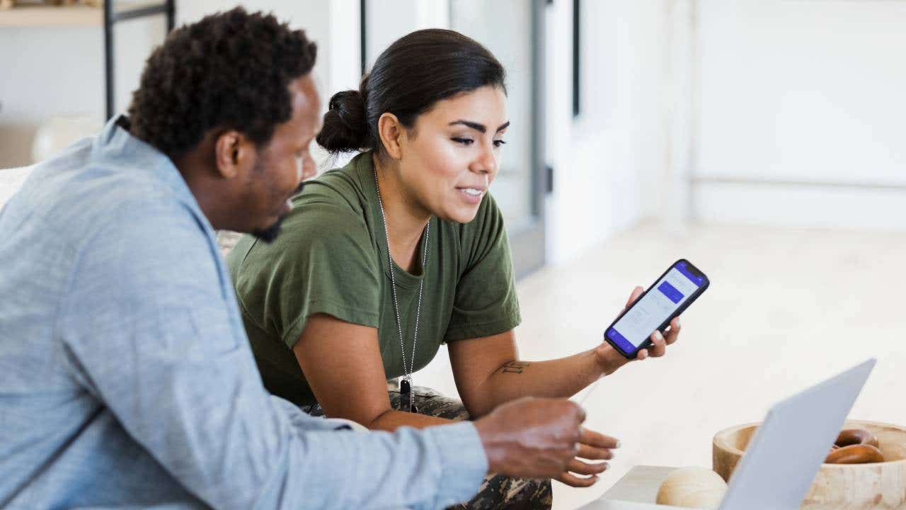 female soldier and her husband use a banking app to check the state of their finances