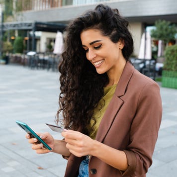 Portrait of a young woman enjoying at the cafe and shopping online