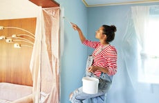 Pregnant woman in bib overalls renovating room